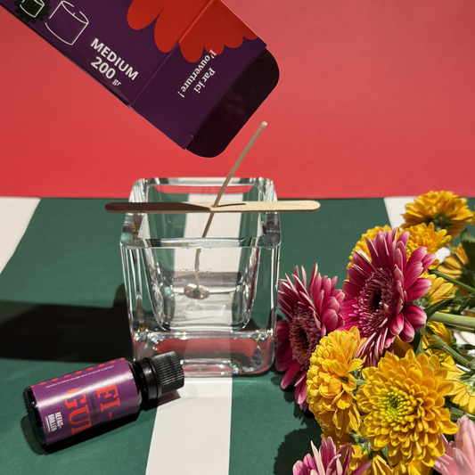 Kit de bougie parfumée en préparation avec parfum figue et mèche dans un verre, décoration originale avec fleurs colorées